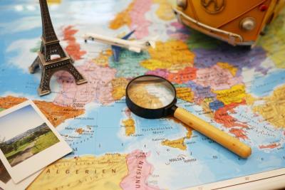 Vakantie met MS - Kaart van Europa met polaroid foto's, mini-Eiffeltoren, modelvliegtuigje, loep en minibus