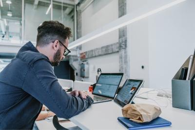 Persoon achter zijn laptop in kantooromgeving
